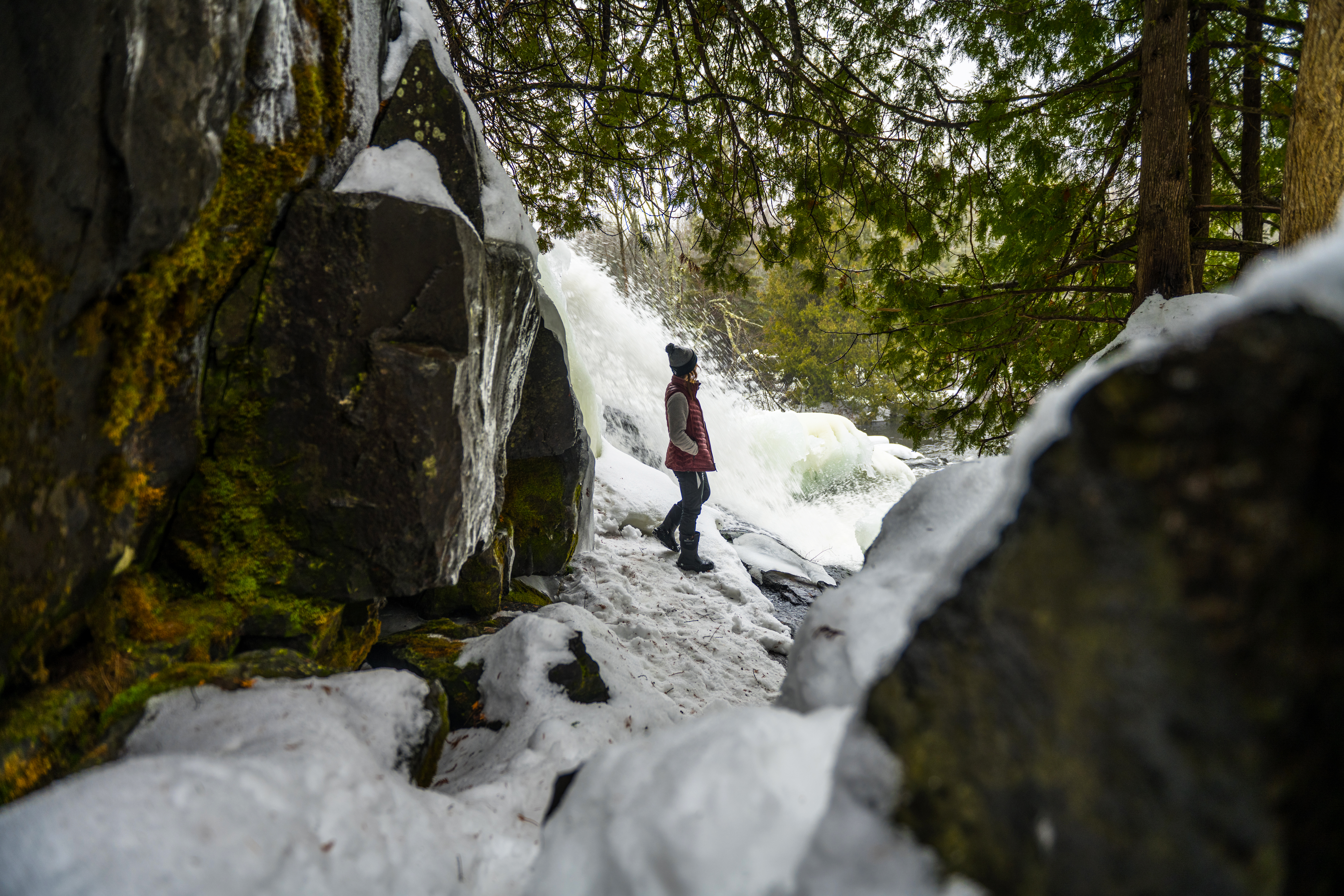 girl by bond falls frozen waterfall winter in porcupine mountains area