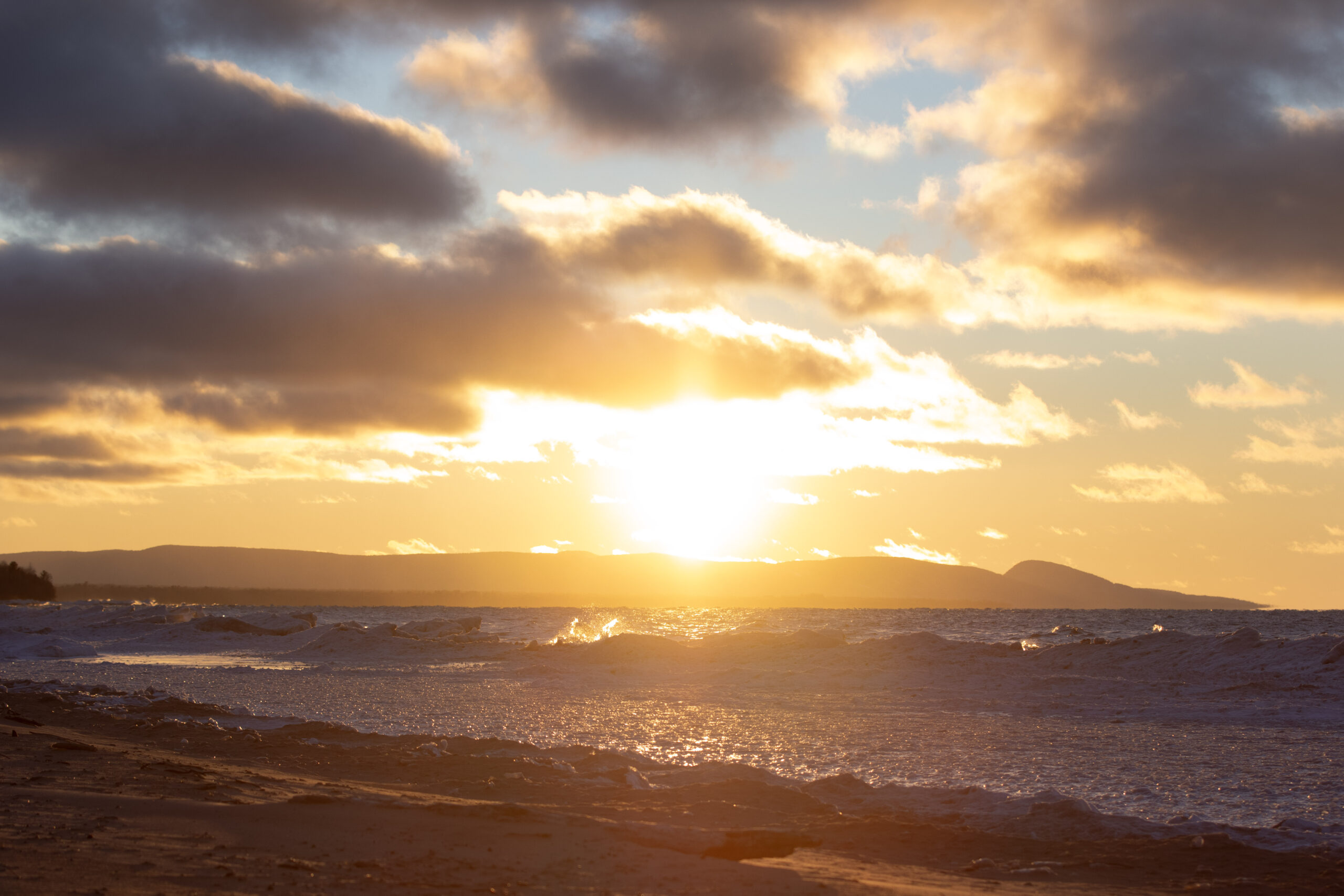 winter sunset on beach with snow at porcupine mountains